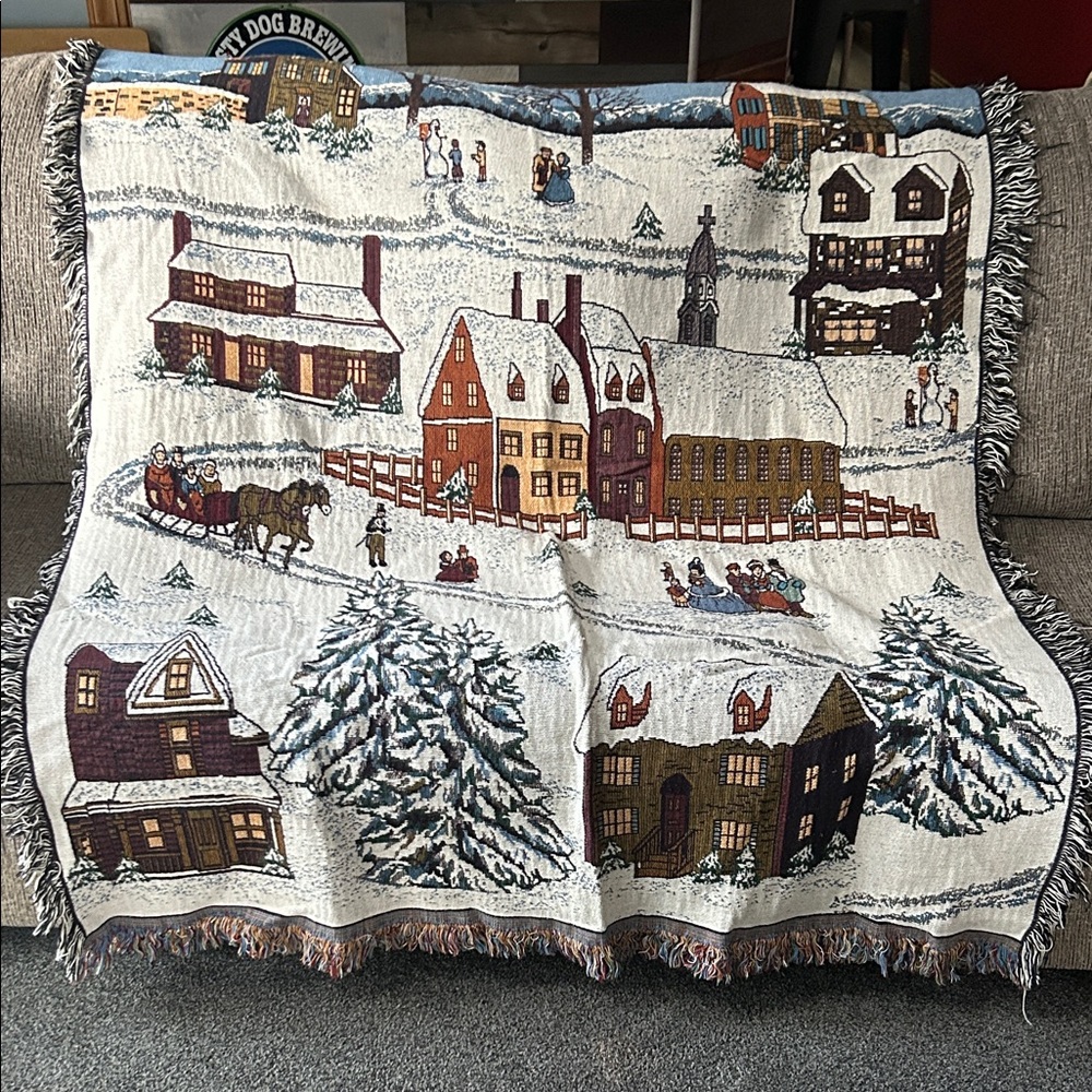 woven tapestry throw blanket featuring a winter village scene fringe edges